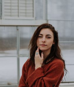 Woman in a red sweater standing outdoors